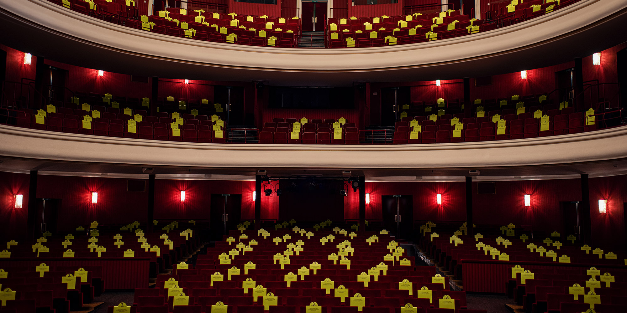 Bild eines Theatersaales in dem jeder dritte Platz auffällig markiert ist.